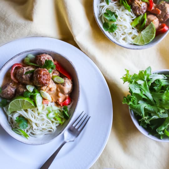 Köttbullar i kokos/currysås serveras med tunna nudlar och limeyoghurt