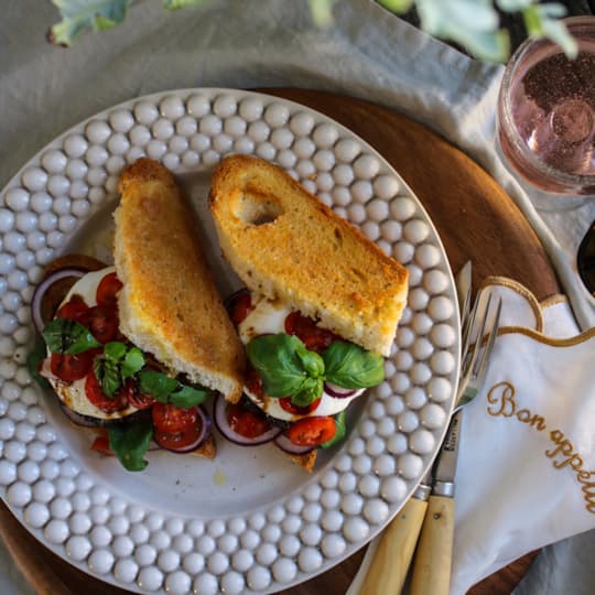 Saftig burgare med fräsch tomat/basilika sallad, mozzarella i vitlöksrostat bröd